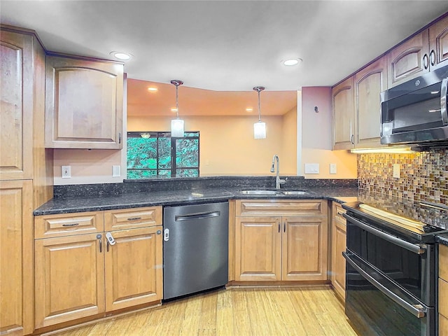 kitchen featuring tasteful backsplash, appliances with stainless steel finishes, sink, light hardwood / wood-style floors, and decorative light fixtures