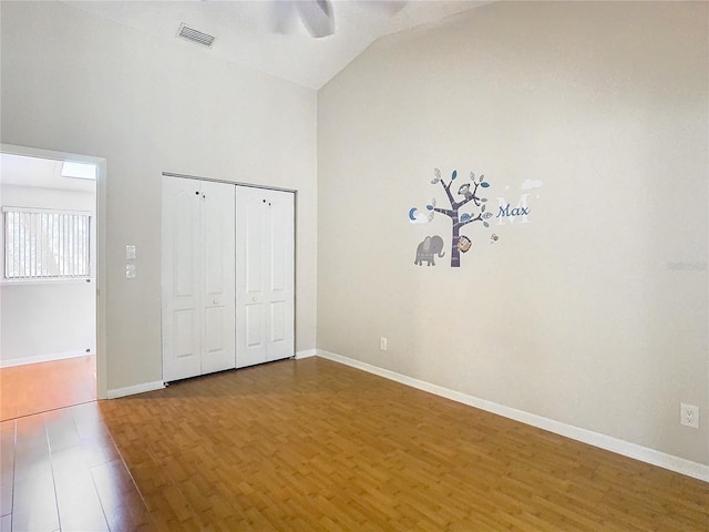 unfurnished bedroom featuring a closet, hardwood / wood-style floors, vaulted ceiling, and ceiling fan