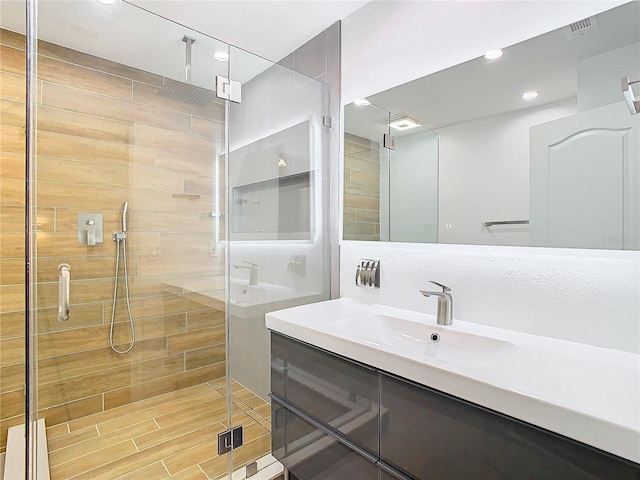 bathroom with vanity and a shower with shower door