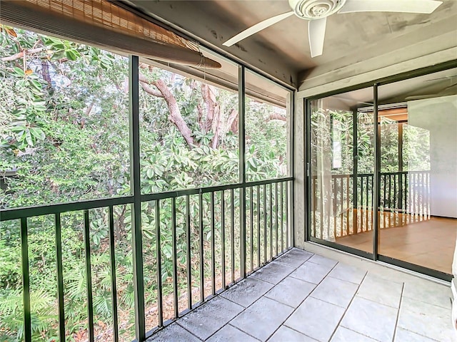 unfurnished sunroom with ceiling fan