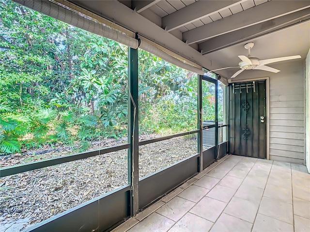 unfurnished sunroom with beamed ceiling, ceiling fan, and plenty of natural light