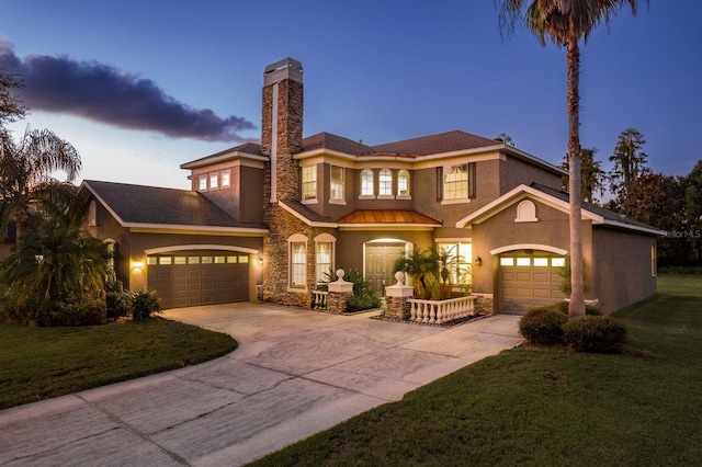 view of front of property with a garage and a yard