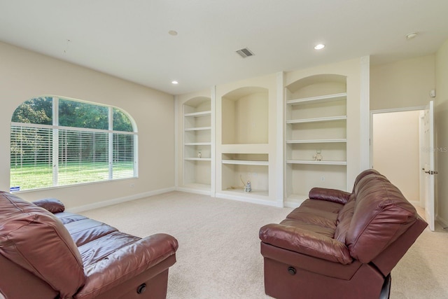 carpeted living room featuring built in shelves