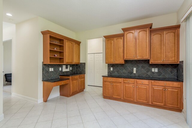 kitchen featuring dark stone countertops, light tile patterned floors, and tasteful backsplash