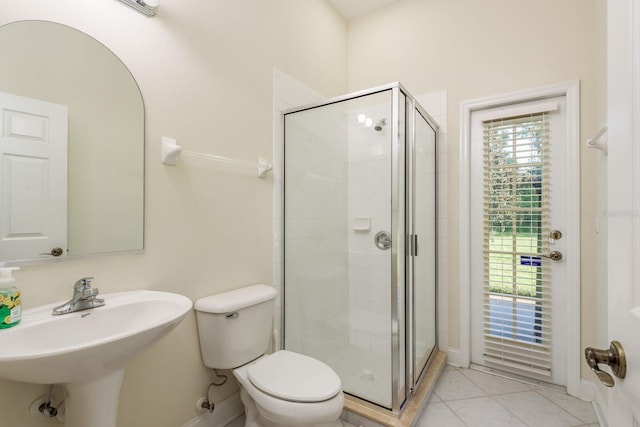 bathroom with tile patterned flooring, a shower with door, toilet, and sink