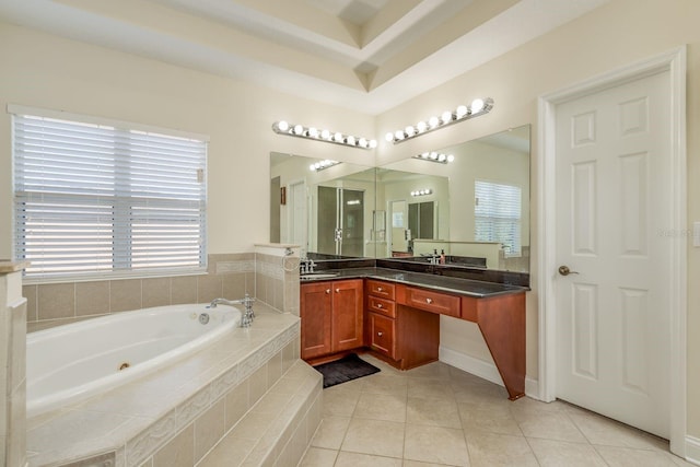 bathroom featuring a healthy amount of sunlight, tile patterned floors, tiled bath, and vanity