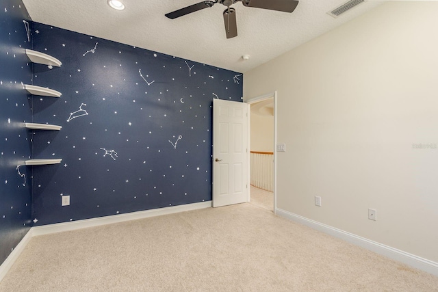 empty room with carpet, a textured ceiling, and ceiling fan