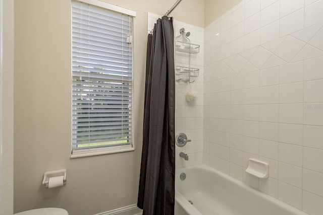 bathroom featuring toilet and shower / bathtub combination with curtain