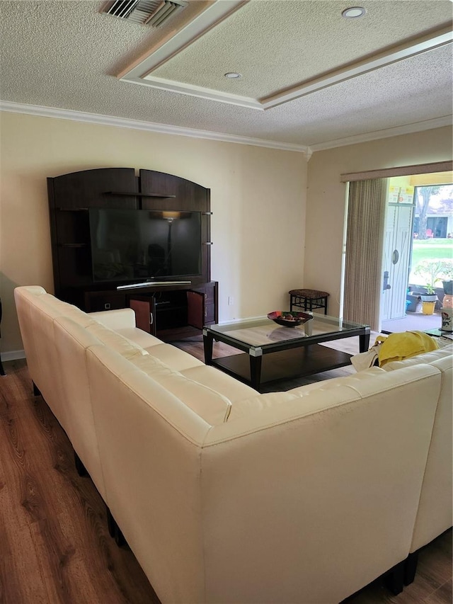 living room featuring dark hardwood / wood-style floors, ornamental molding, and a textured ceiling