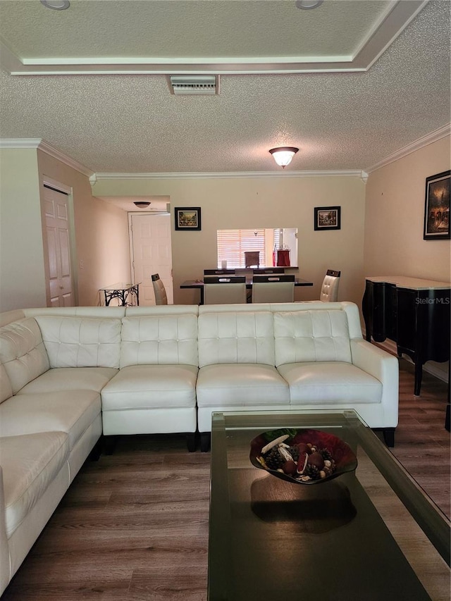 living room with a textured ceiling, crown molding, and dark hardwood / wood-style floors