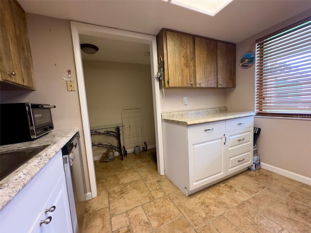 kitchen with dishwasher, white cabinetry, and sink