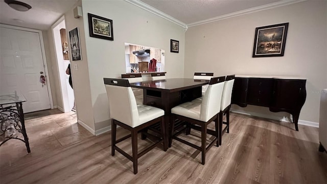 dining space featuring hardwood / wood-style floors, a textured ceiling, and crown molding