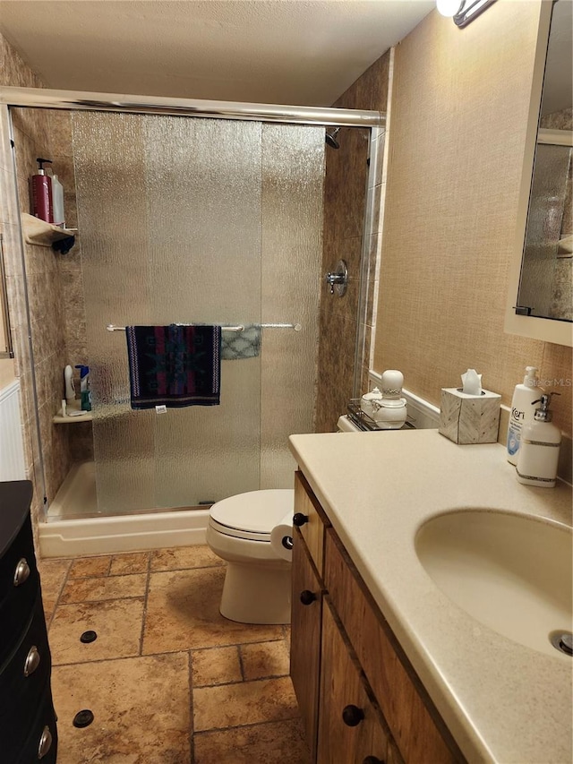 bathroom featuring vanity, toilet, and an enclosed shower