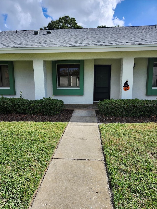 entrance to property featuring a lawn