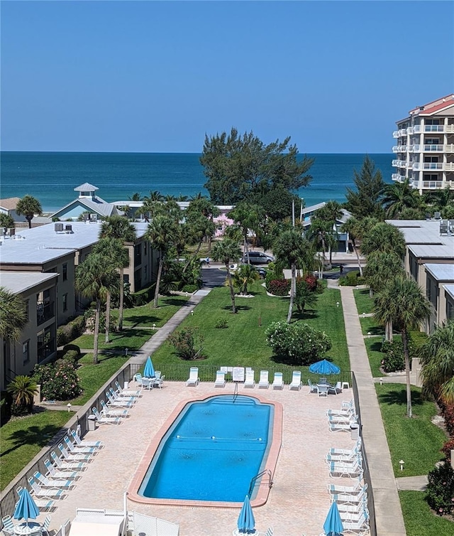 view of swimming pool with a yard, a water view, and a patio area