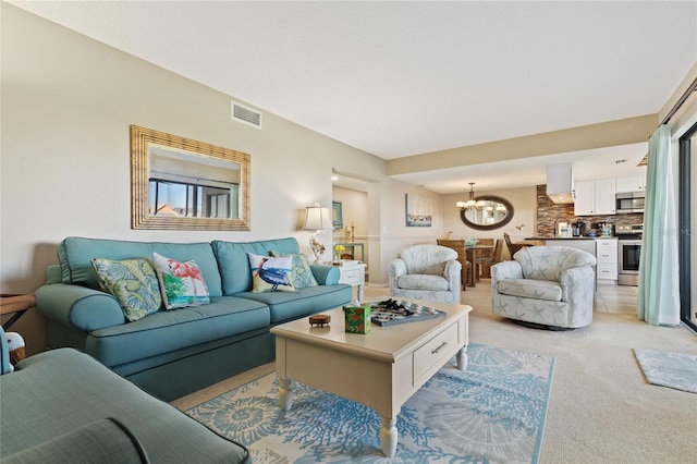 living room featuring light carpet and an inviting chandelier