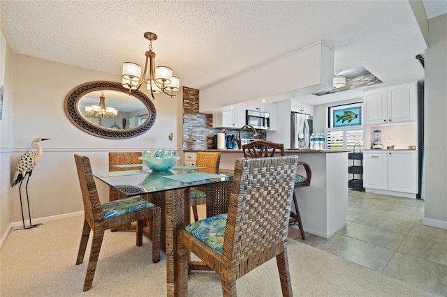 dining area featuring a textured ceiling, a chandelier, and light tile patterned floors