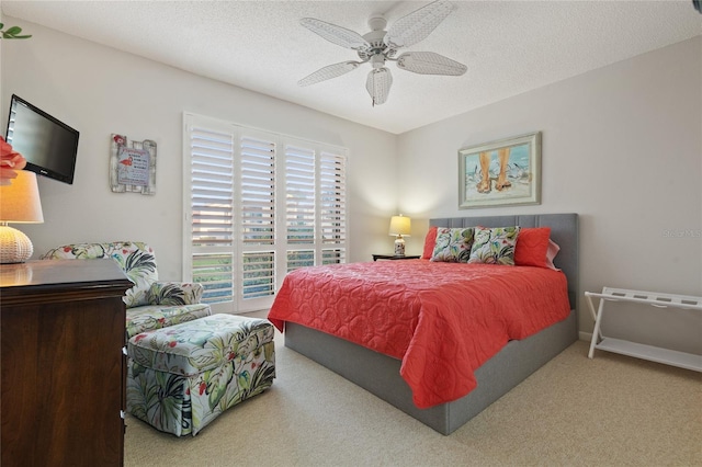 bedroom with ceiling fan, a textured ceiling, and carpet floors