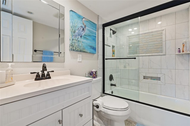 full bathroom featuring bath / shower combo with glass door, vanity, and toilet