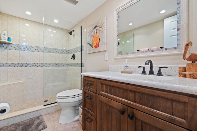 bathroom featuring toilet, vanity, tile patterned flooring, and tiled shower