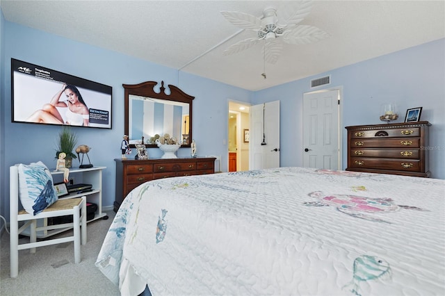 bedroom featuring carpet flooring, ensuite bath, a textured ceiling, and ceiling fan