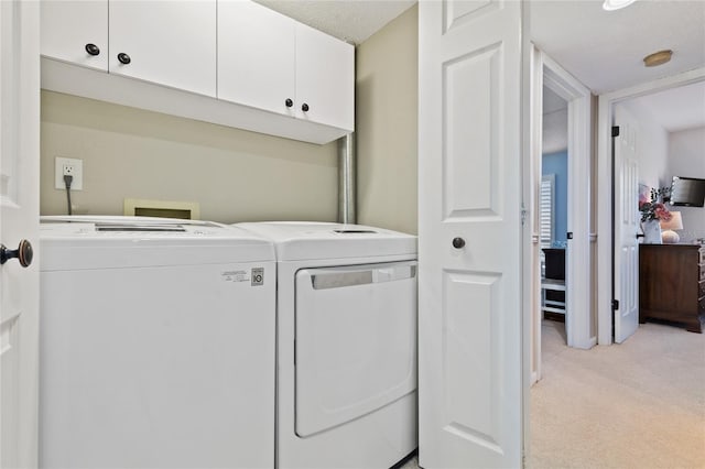 washroom with cabinets, separate washer and dryer, a textured ceiling, and light carpet