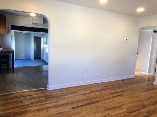 spare room with dark wood-type flooring