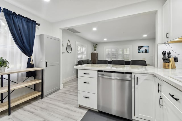 kitchen featuring kitchen peninsula, tasteful backsplash, white cabinetry, dishwasher, and light wood-type flooring