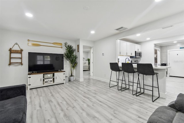 living room with sink and light hardwood / wood-style floors