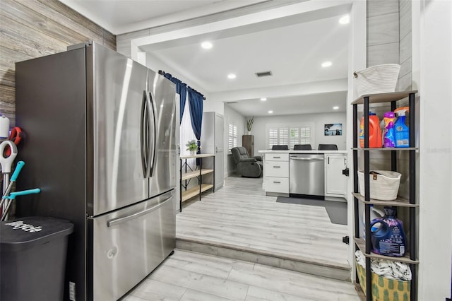 kitchen with light hardwood / wood-style flooring, stainless steel appliances, and white cabinetry