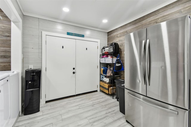 kitchen with light wood-type flooring, stainless steel fridge, and washer and dryer