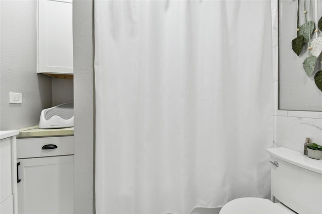 bathroom with a shower with curtain, vanity, toilet, and tasteful backsplash