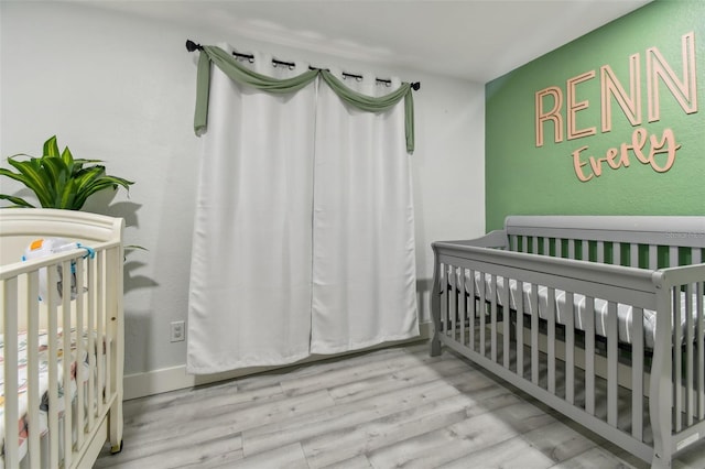 bedroom featuring light hardwood / wood-style floors and a nursery area