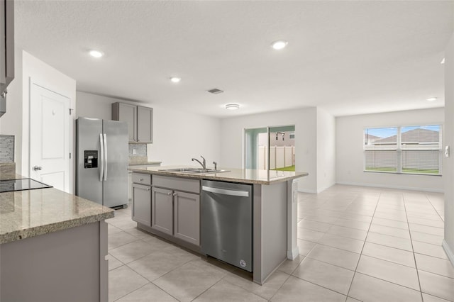 kitchen featuring a kitchen island with sink, appliances with stainless steel finishes, gray cabinets, and sink