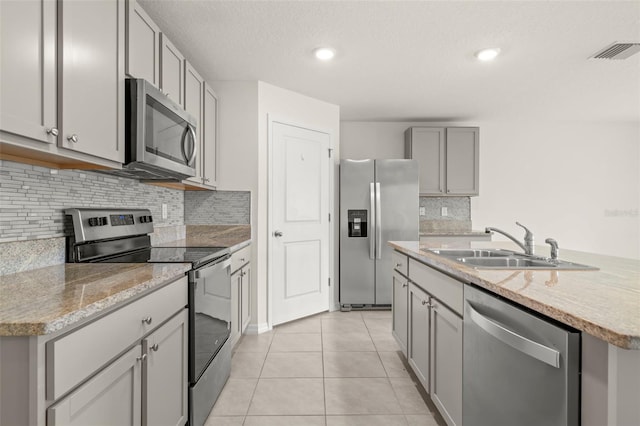 kitchen featuring a textured ceiling, gray cabinetry, stainless steel appliances, sink, and light tile patterned flooring