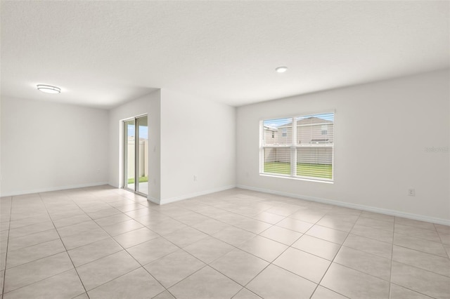 tiled spare room featuring a textured ceiling