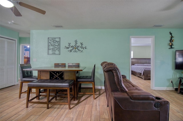 dining area featuring a textured ceiling, light hardwood / wood-style flooring, and ceiling fan