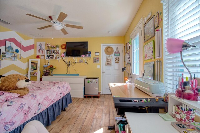 bedroom with light wood-type flooring, multiple windows, and ceiling fan