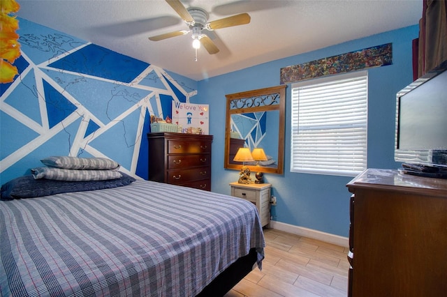 bedroom with light wood-type flooring, a textured ceiling, and ceiling fan