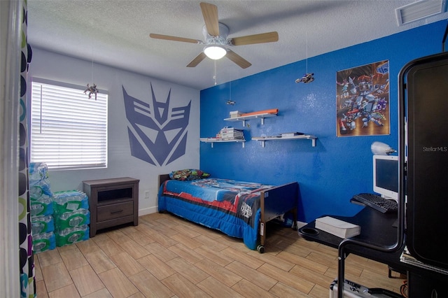 bedroom with a textured ceiling, ceiling fan, and wood-type flooring