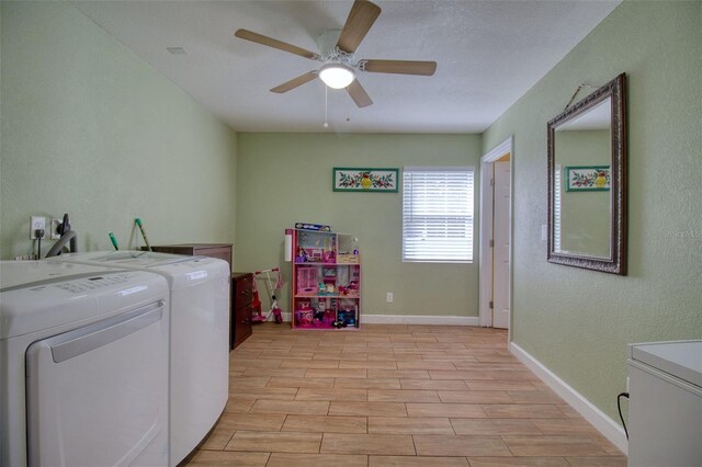 laundry room with a textured ceiling, washing machine and dryer, ceiling fan, and light wood-type flooring