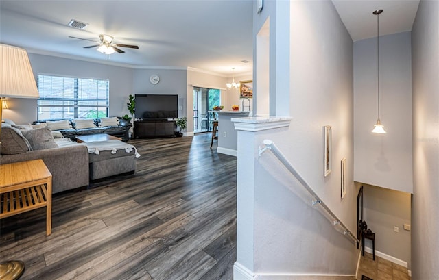 living room featuring dark wood-type flooring, ceiling fan with notable chandelier, sink, and ornamental molding