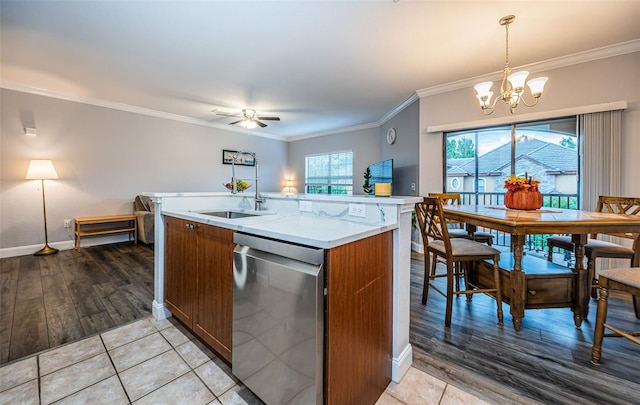 kitchen featuring light wood-type flooring, ceiling fan with notable chandelier, pendant lighting, and stainless steel dishwasher