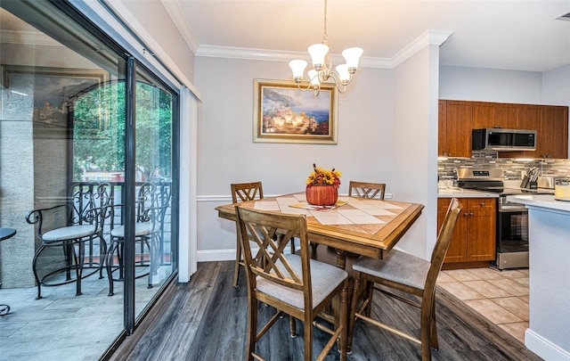 dining area with an inviting chandelier, crown molding, and light hardwood / wood-style flooring