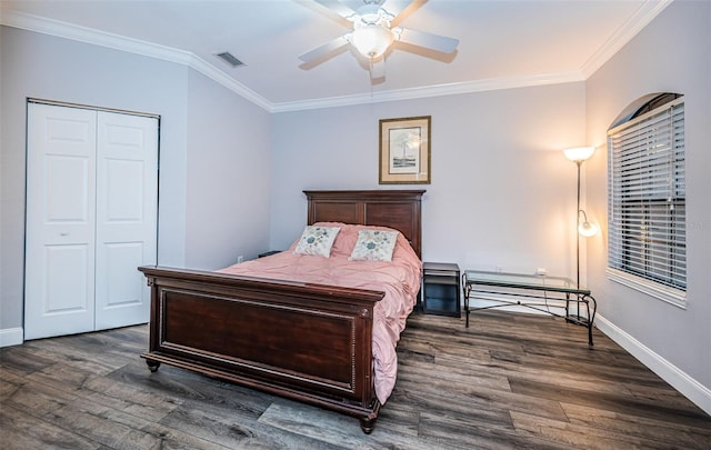 bedroom featuring dark wood-type flooring, a closet, ceiling fan, and crown molding