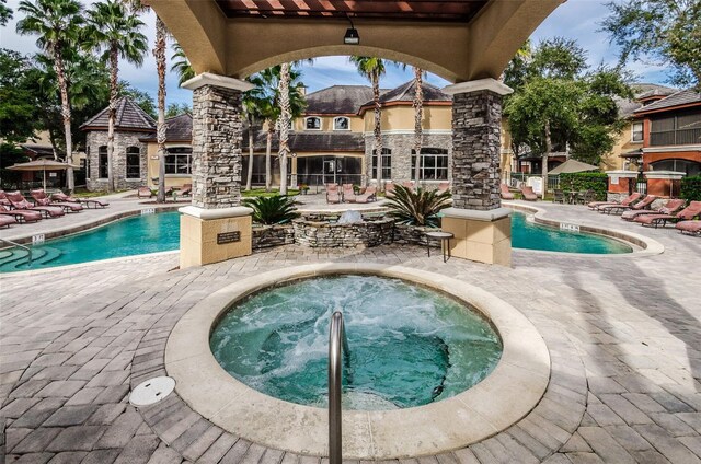 view of swimming pool with a community hot tub and a patio