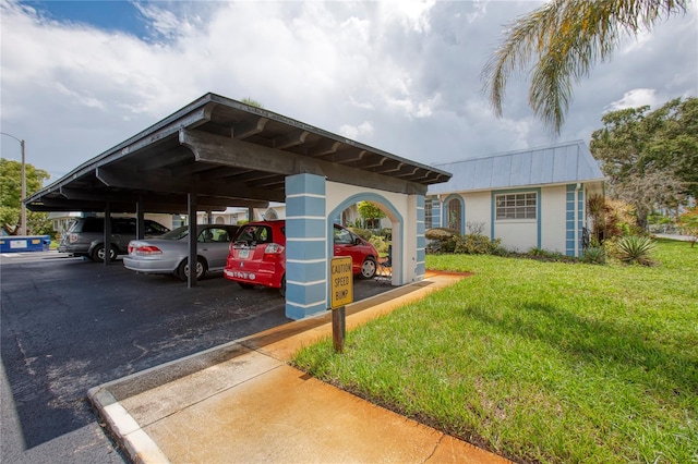 view of parking / parking lot with a yard and a carport