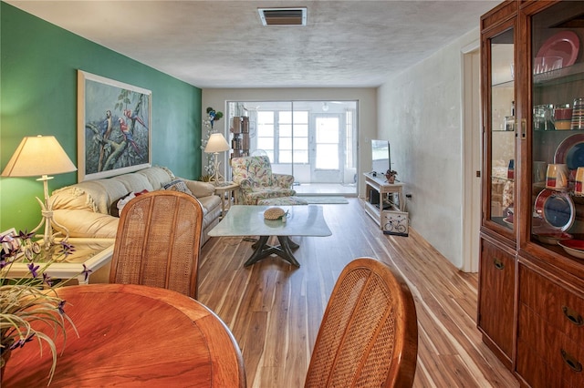 dining area with hardwood / wood-style flooring and a textured ceiling