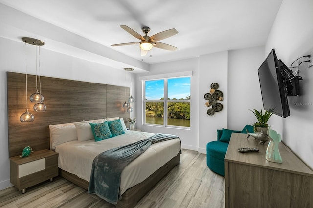 bedroom with light wood-style flooring, baseboards, and ceiling fan