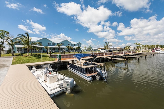 view of dock featuring a residential view, a water view, and a yard
